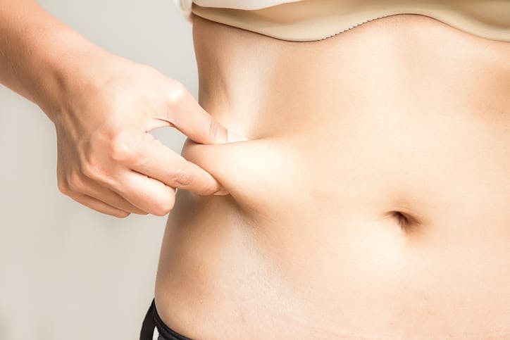 Woman pinching her midsection