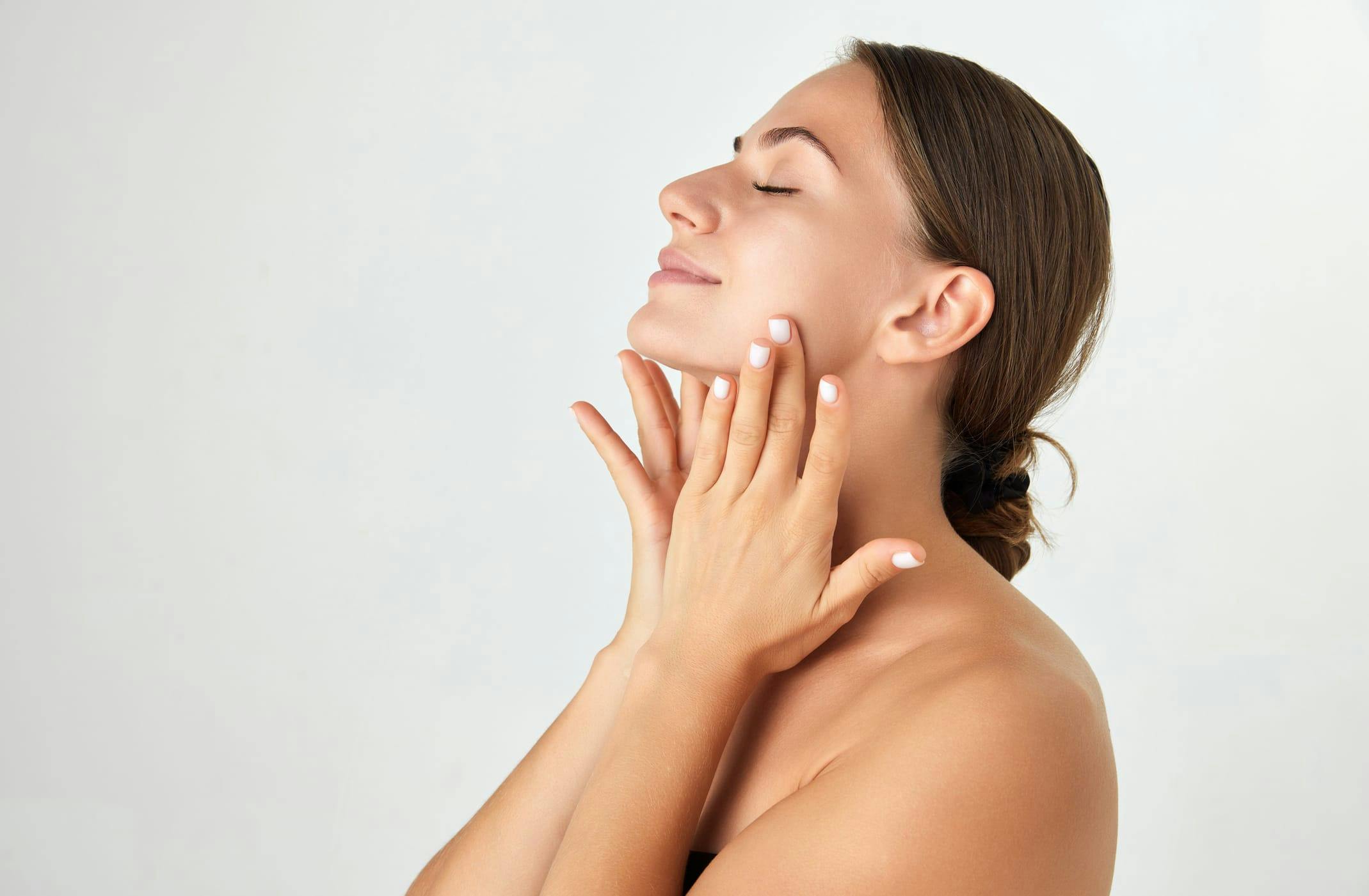 Woman smiling and feeling her cheeks