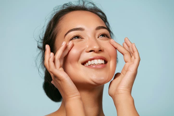 Woman running her fingers over her cheeks