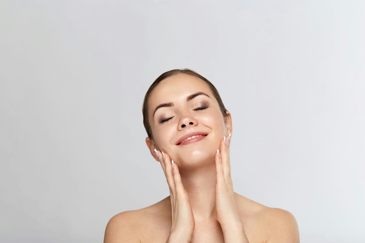 Woman smiling and feeling her cheeks
