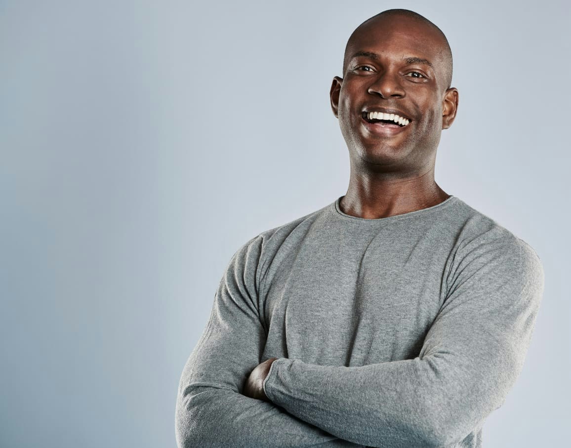 African American man smiling with his arms crossed