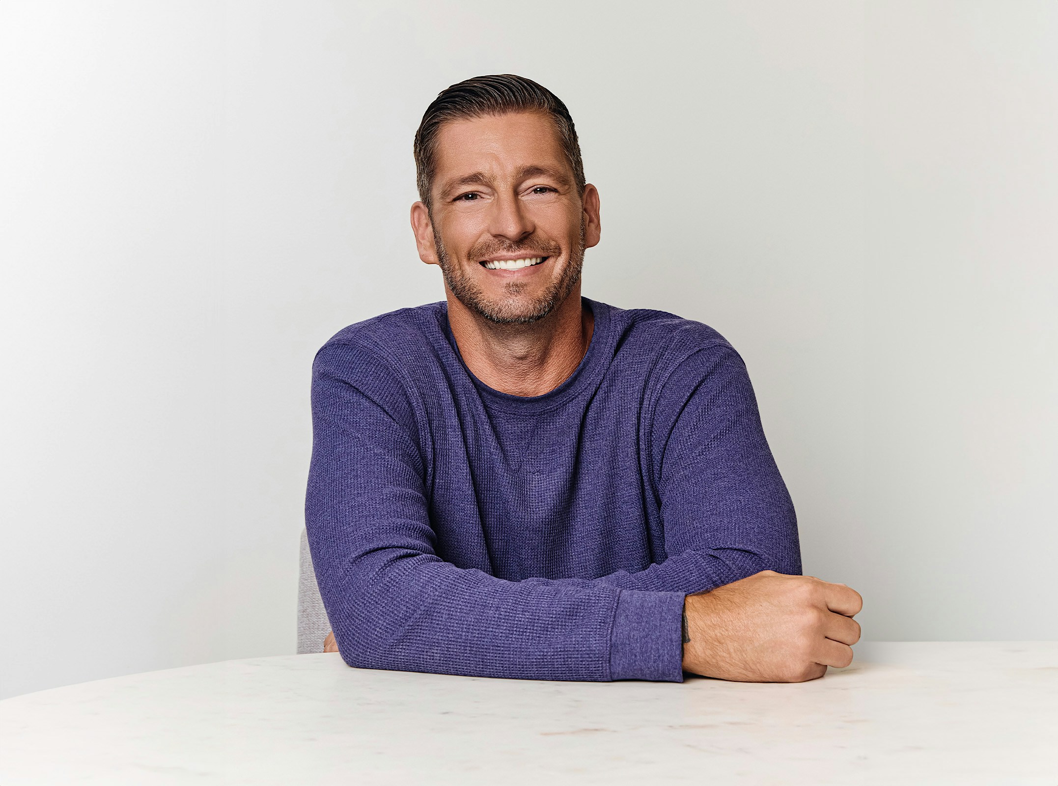 A man in a blue shirt smiling