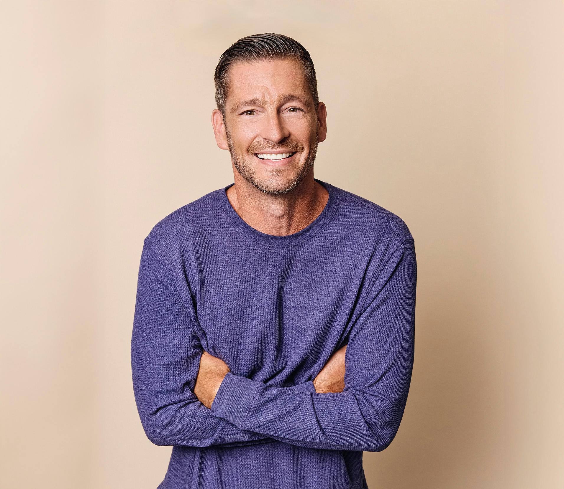 Man smiling with his arms crossed