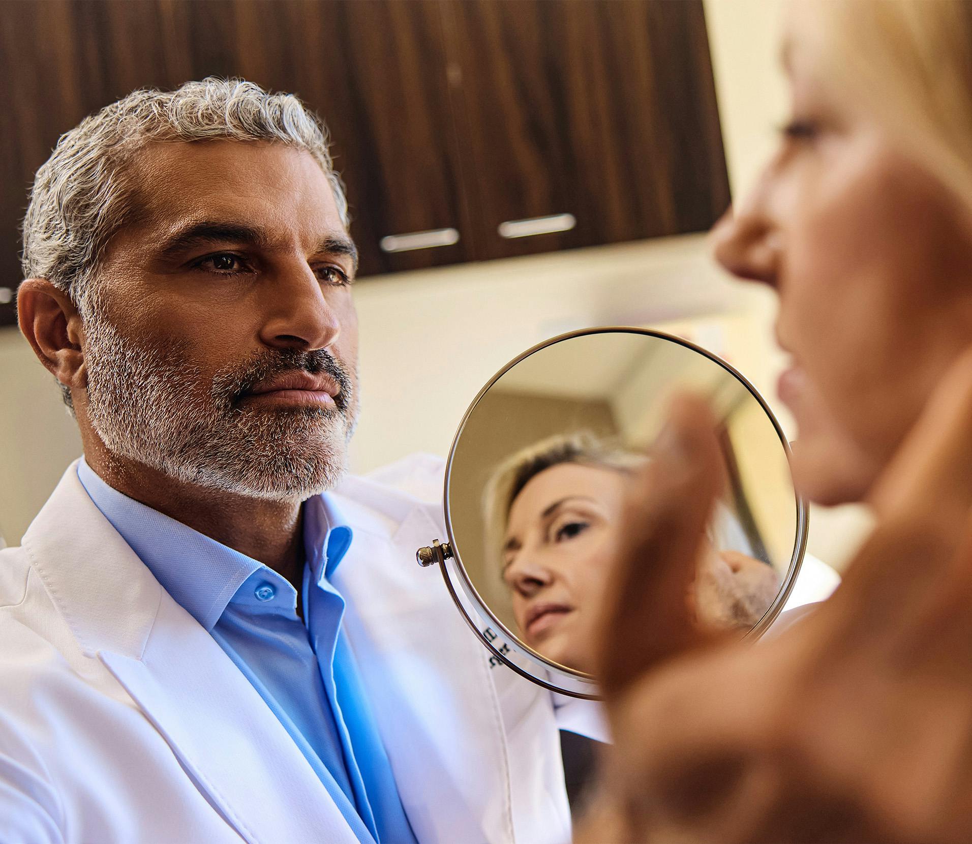 Dr. Karam holding a mirror for a patient