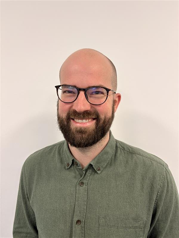 Portrait of Casper Barner, a ServiceNow professional, wearing glasses and a green shirt.