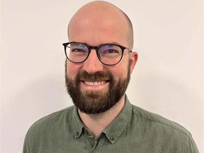Portrait of Casper Barner, a ServiceNow professional, wearing glasses and a green shirt.