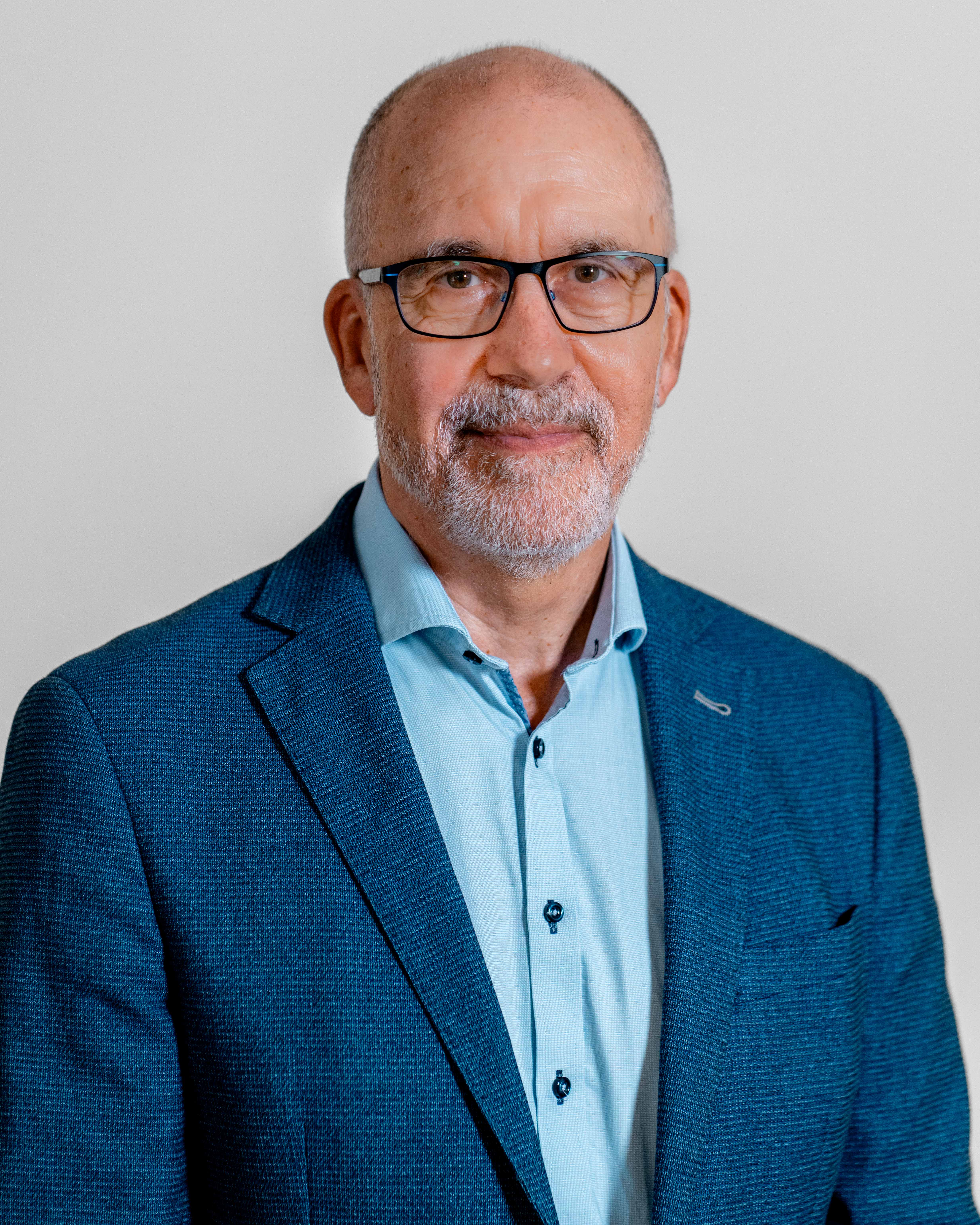 Portrait of Erik Bartholdy, a ServiceNow professional, wearing a blue blazer and glasses.