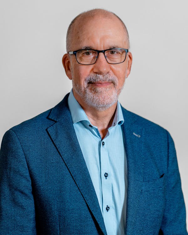 Portrait of Erik Bartholdy, a ServiceNow professional, wearing a blue blazer and glasses.