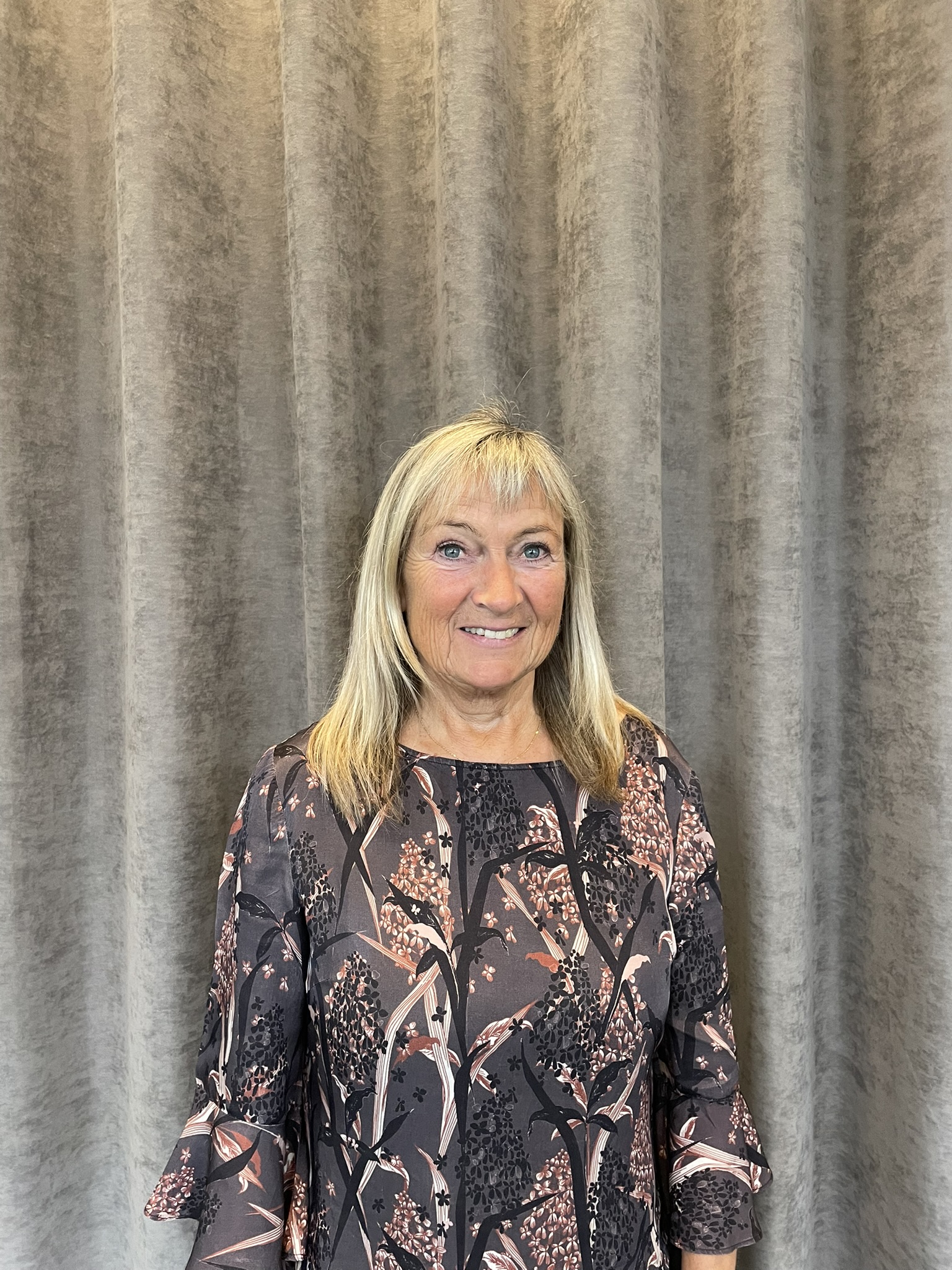 Portrait of Karin Vinther, a ServiceNow professional, standing in front of a grey curtain.