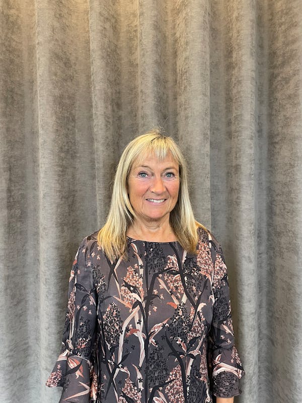 Portrait of Karin Vinther, a ServiceNow professional, standing in front of a grey curtain.