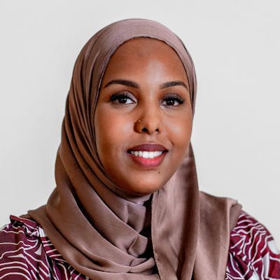 Portrait of Muna Ahmed Mohammed, a ServiceNow professional, wearing a hijab and a patterned top.