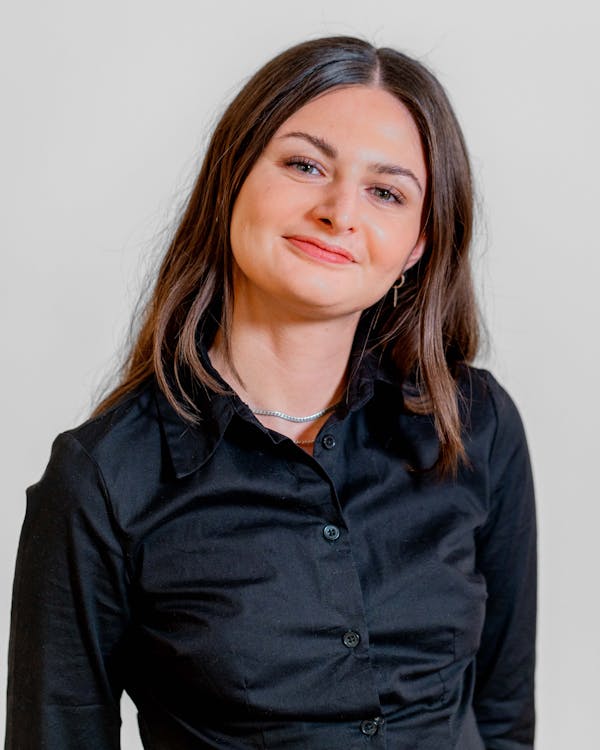 Portrait of Sabina Khan Nielsen, a ServiceNow professional, smiling and wearing a black shirt.