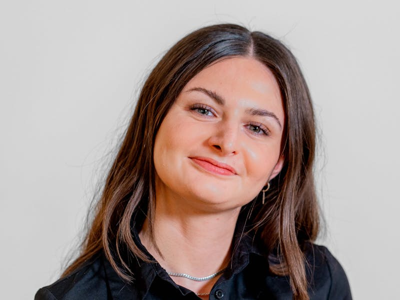 Portrait of Sabina Khan Nielsen, a ServiceNow professional, smiling and wearing a black shirt.