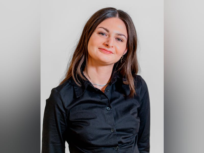 Portrait of Sabina Khan Nielsen, a ServiceNow professional, smiling and wearing a black shirt.