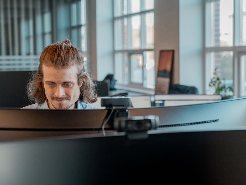 A man working at a computer in an office at ServiceNow partner Adeno.
