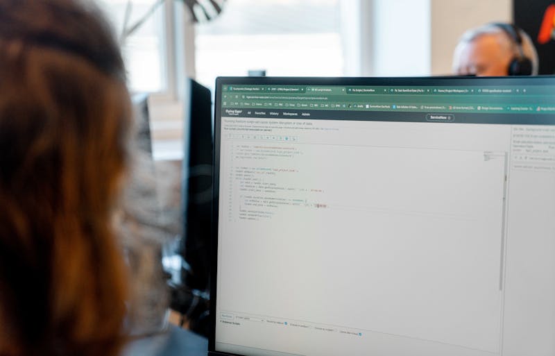 A person looking at a computer screen displaying code within the ServiceNow platform.