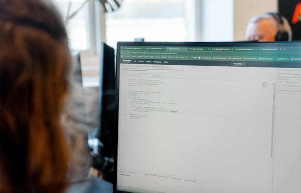 A person looking at a computer screen displaying code within the ServiceNow platform.