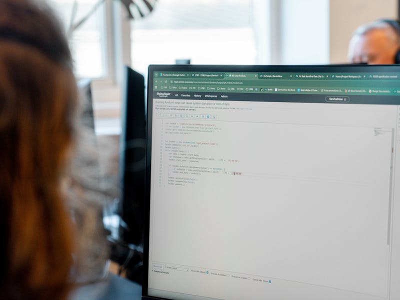 A person looking at a computer screen displaying code within the ServiceNow platform.