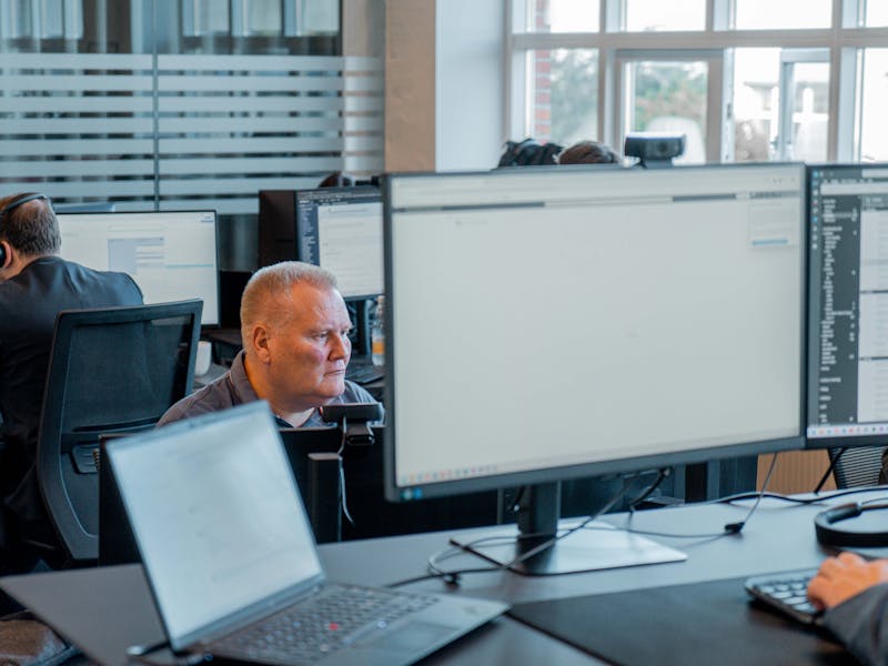 Professionals working at computer workstations in a modern office environment using ServiceNow.