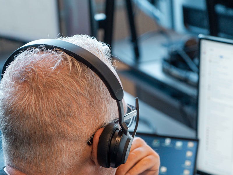 A ServiceNow professional wearing a headset and working at a computer.