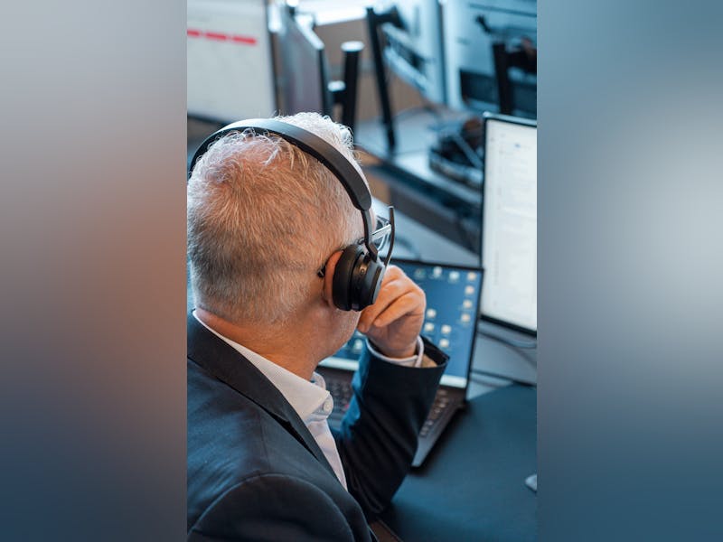 A ServiceNow professional wearing a headset and working at a computer.