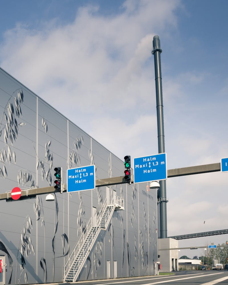 Exterior view of the Fjernvarme Fyn straw-fired power plant building with grain illustrations on the facade, highlighting a ServiceNow implementation.