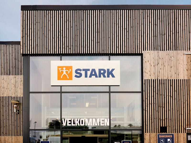 Exterior of a STARK store with wooden slat walls and a glass entrance, featuring a ServiceNow solution.