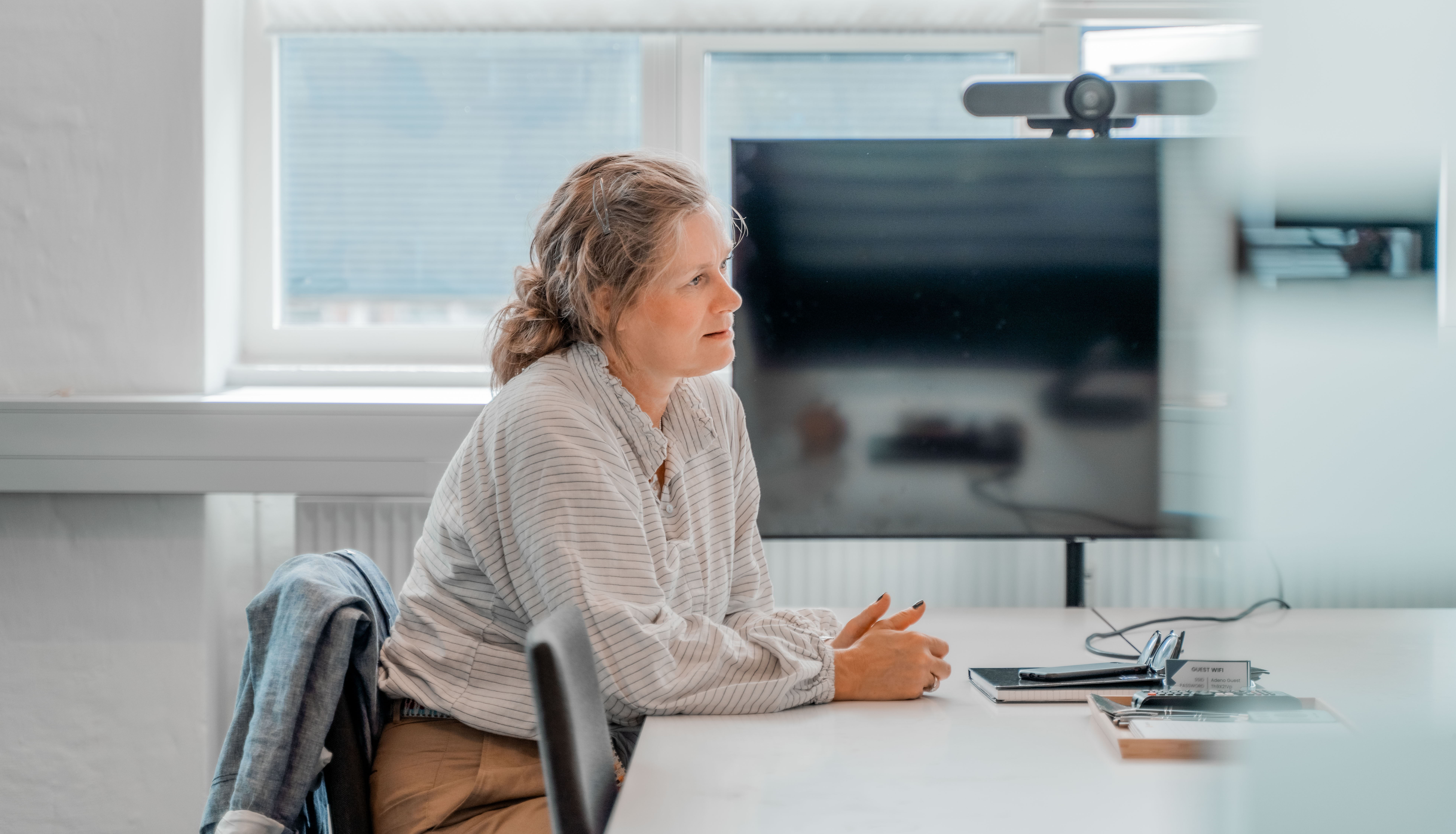 A woman sitting at a table in an office setting at a ServiceNow partner.