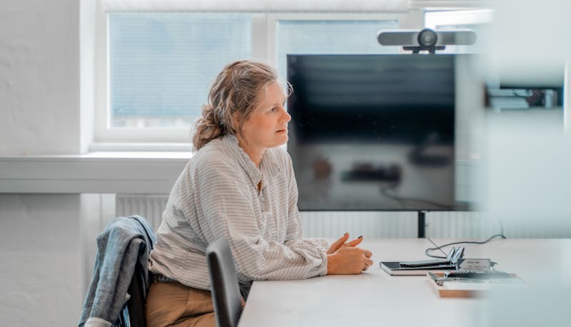 A woman sitting at a table in an office setting at a ServiceNow partner.