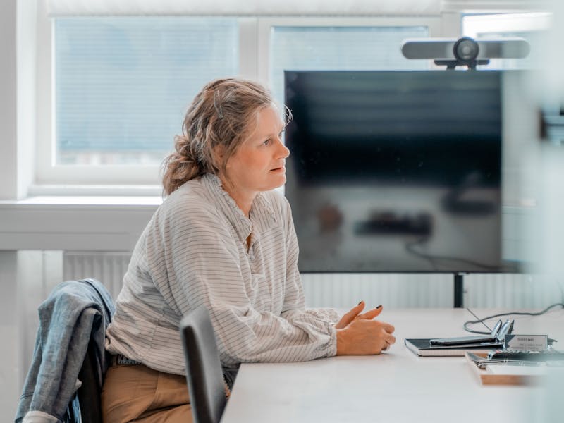 A woman sitting at a table in an office setting at a ServiceNow partner.