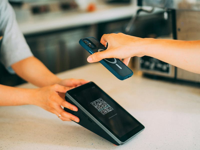 A person scanning a QR code on a tablet with a smartphone for ServiceNow reservation management.