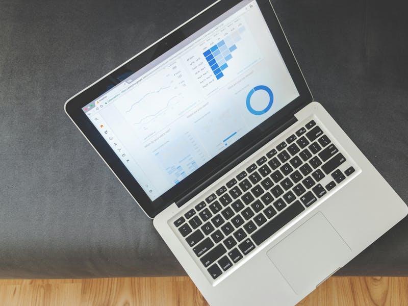 A wooden desk with a keyboard, pen, smartphone, and printed ServiceNow analytics reports.