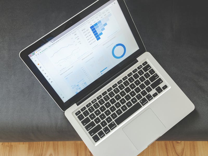 A wooden desk with a keyboard, pen, smartphone, and printed ServiceNow analytics reports.