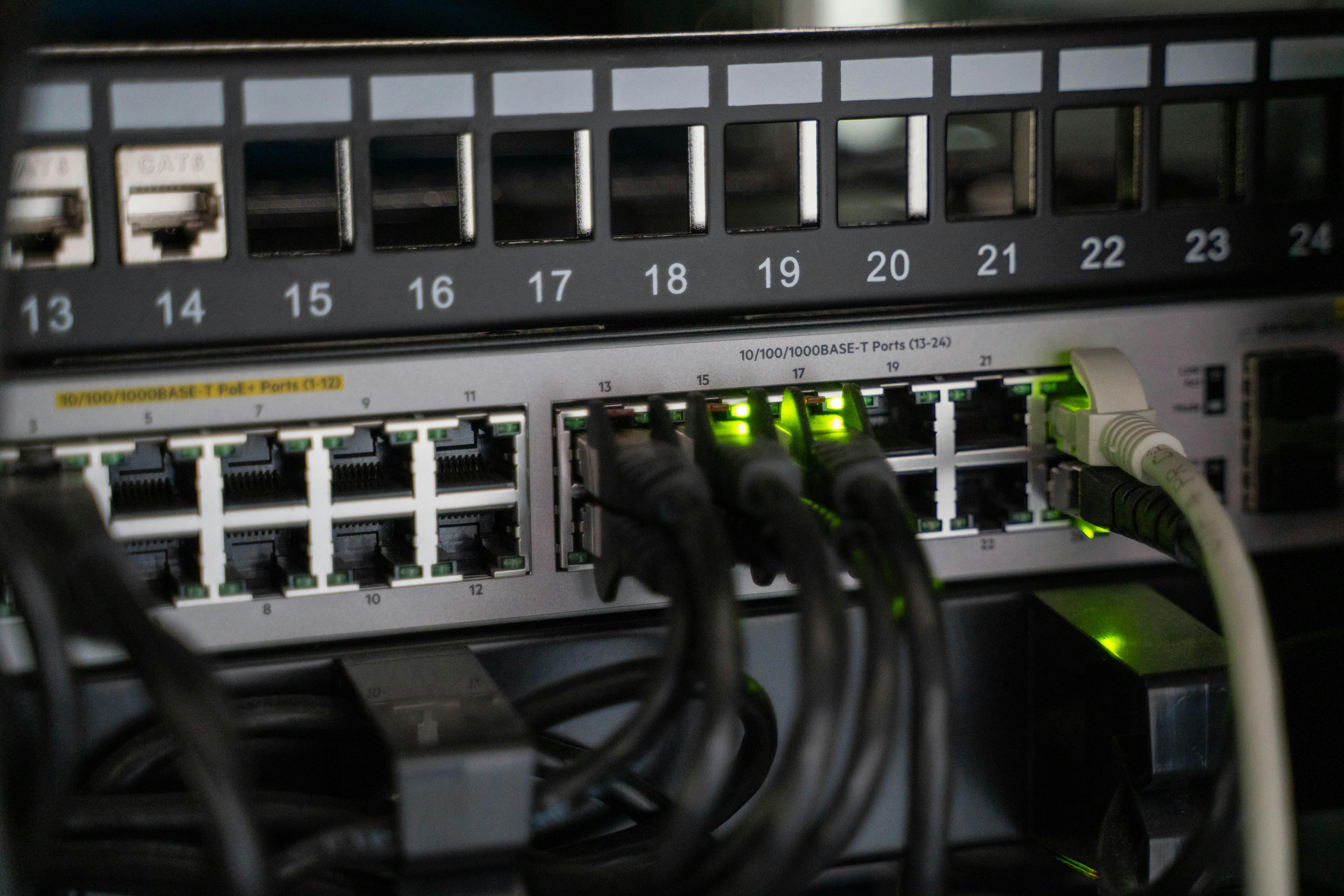 Close-up of a network switch with ethernet cables and green indicator lights for ServiceNow IntegrationHub ETL.
