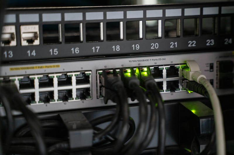 Close-up of a network switch with ethernet cables and green indicator lights for ServiceNow IntegrationHub ETL.
