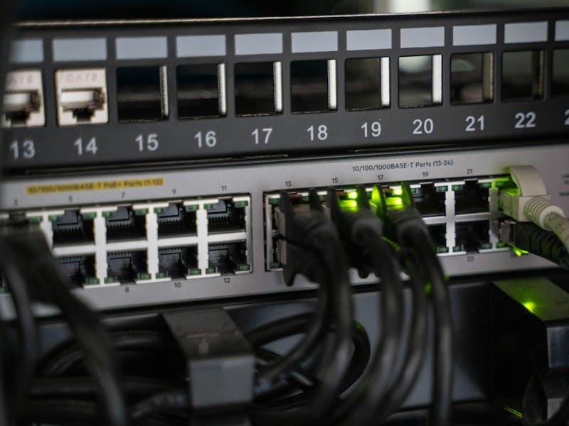 Close-up of a network switch with ethernet cables and green indicator lights for ServiceNow IntegrationHub ETL.