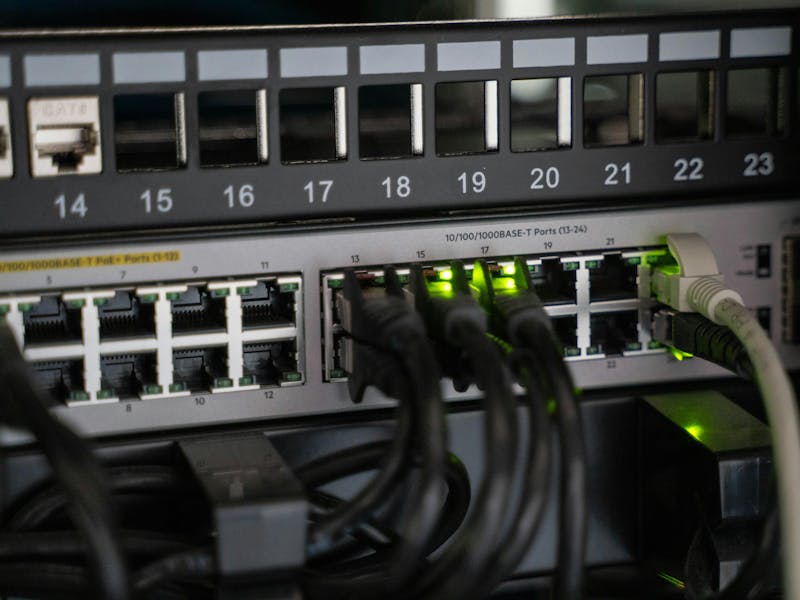 Close-up of a network switch with ethernet cables and green indicator lights for ServiceNow IntegrationHub ETL.