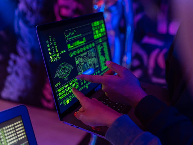 Two people pointing at a laptop screen displaying technical data and graphics for a ServiceNow Instance Scan.