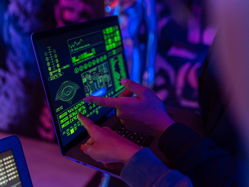 Two people pointing at a laptop screen displaying technical data and graphics for a ServiceNow Instance Scan.