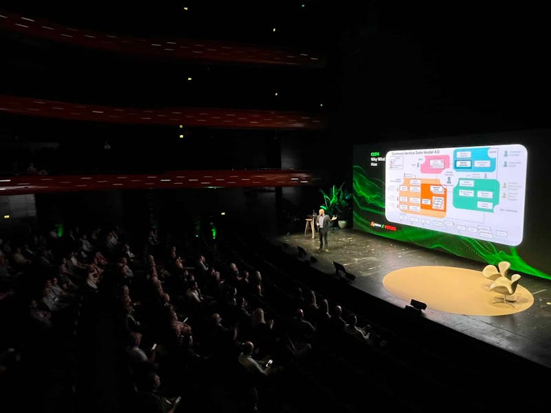 A speaker on stage presenting a slide about the Common Service Data Model 4.0 at the ServiceNow Summit 2024.