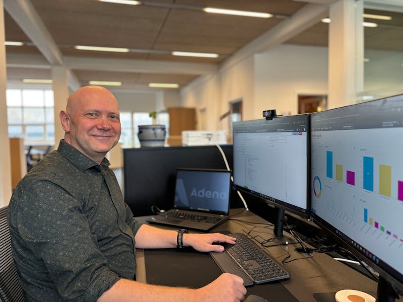 Thomas Vogh Olsen sitting at a desk with monitors displaying the ServiceNow platform.