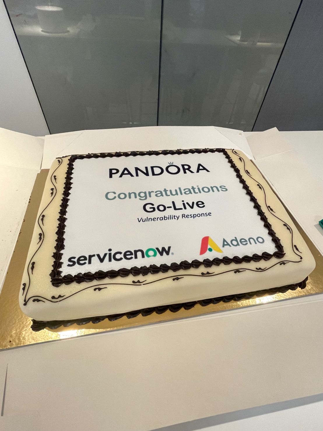 A celebratory cake for the Pandora Vulnerability Response go-live, featuring the ServiceNow, Pandora, and Adeno logos.