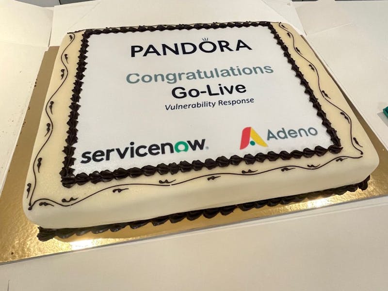 A celebratory cake for the Pandora Vulnerability Response go-live, featuring the ServiceNow, Pandora, and Adeno logos.