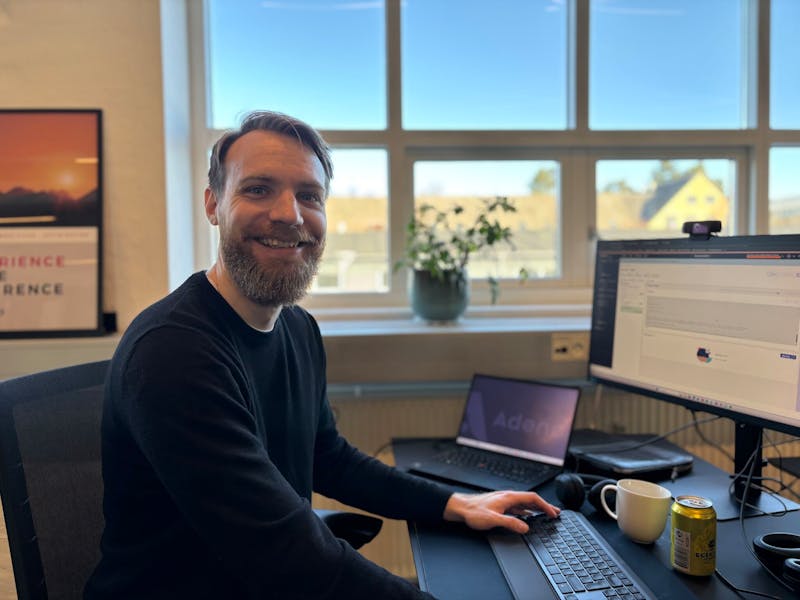A man sitting at a desk with a computer and laptop, working as a ServiceNow consultant.
