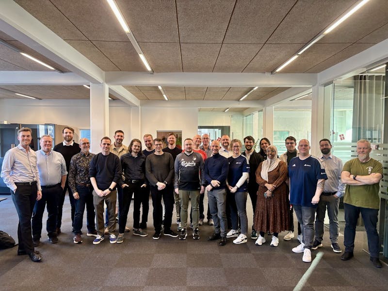 A group of Adeno employees, a ServiceNow partner, posing for a photo in an office to celebrate the company's third anniversary.