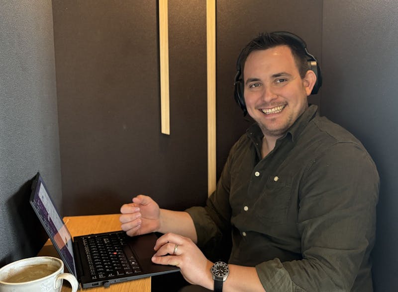 Adam Larsen, a ServiceNow consultant, working at a laptop while wearing headphones.