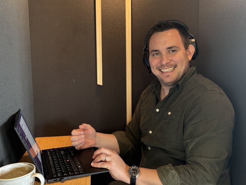 Adam Larsen, a ServiceNow consultant, working at a laptop while wearing headphones.