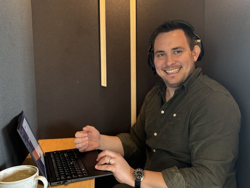Adam Larsen, a ServiceNow consultant, working at a laptop while wearing headphones.