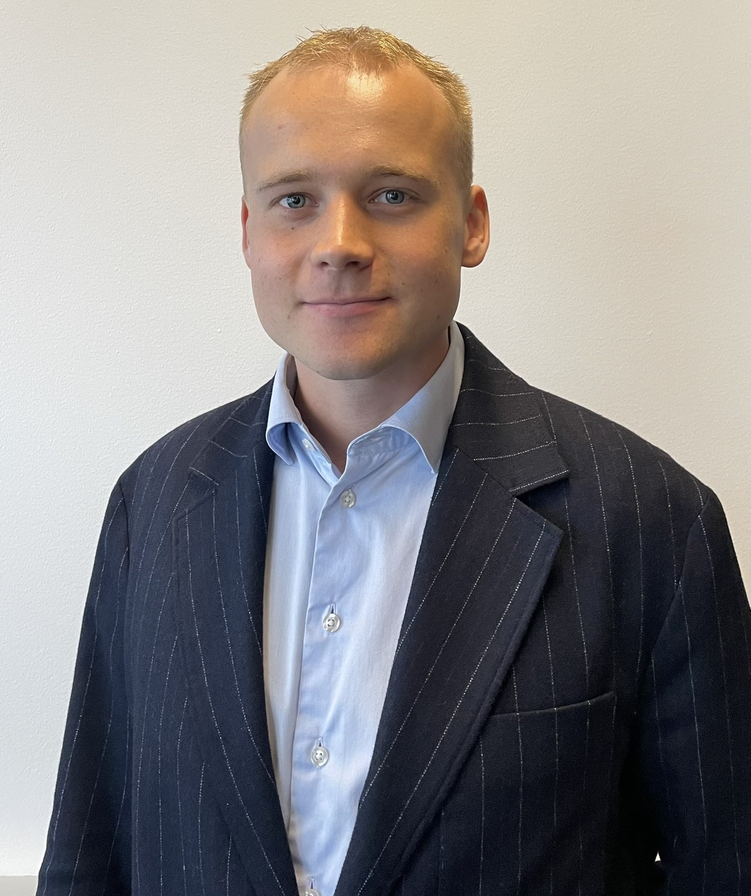 Portrait of ServiceNow professional Alfred Steensen wearing a pinstripe blazer and light blue shirt.