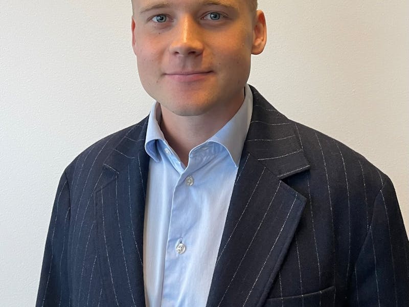 Portrait of ServiceNow professional Alfred Steensen wearing a pinstripe blazer and light blue shirt.